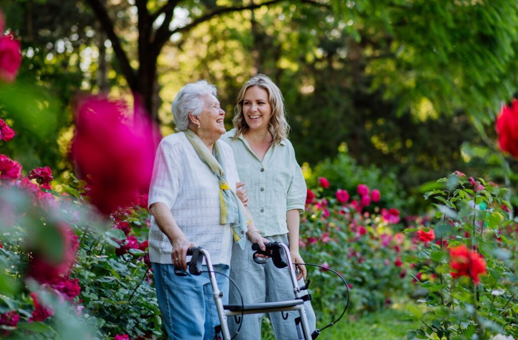 A daughter walking outside with her mother, visiting her at an assisted living facility.