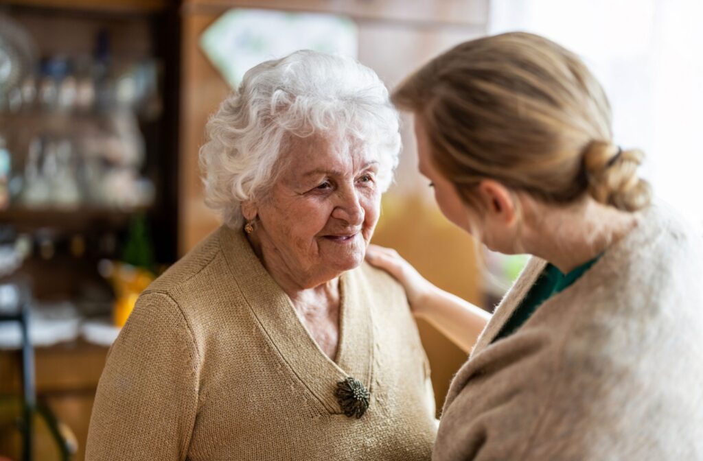 A caregiver supports an elderly individual with dementia offering reassurance and understanding.