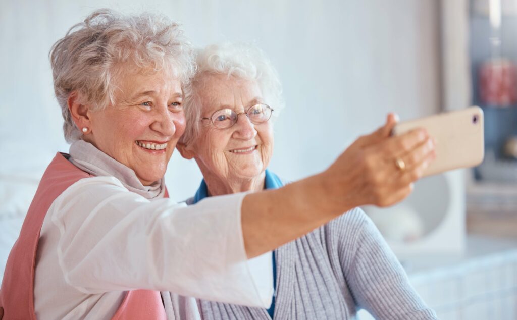 Two senior friends take a selfie for social media together.