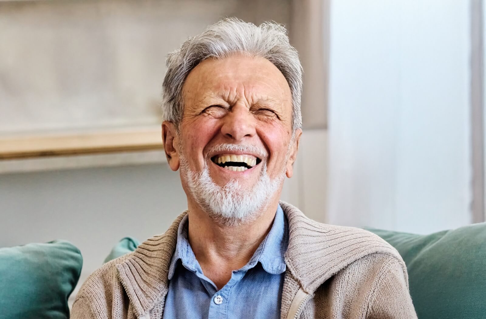Smiling senior relaxing on a couch enjoying retirement lifestyle in an assisted living community